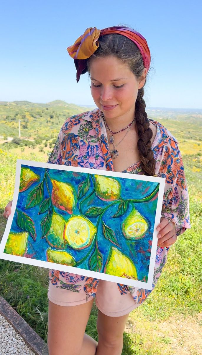 Melina holding Lemons outdoors, with green hills behind her